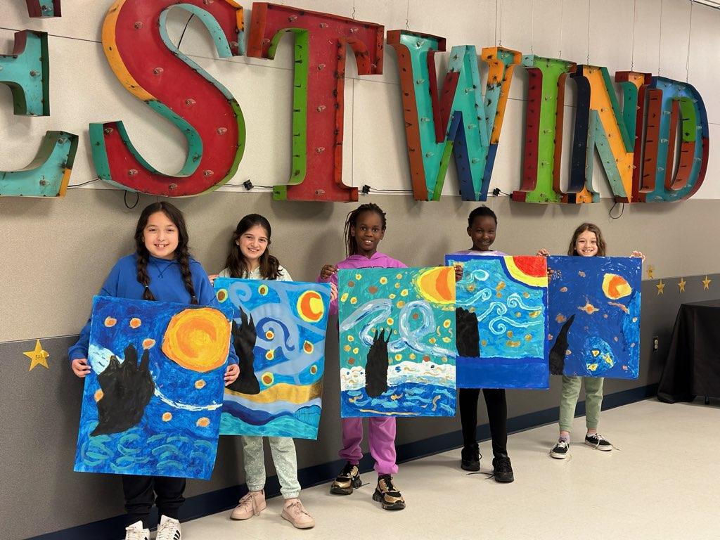 group of westwind kids holding up artwork